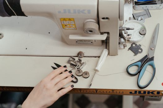 Machine à coudre avec des outils et des accessoires pour créer une trousse d'écolier sur mesure.