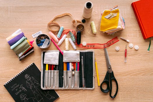 Atelier de couture avec fils, tissus, ciseaux et accessoires pour créer des pochettes et sacs uniques.